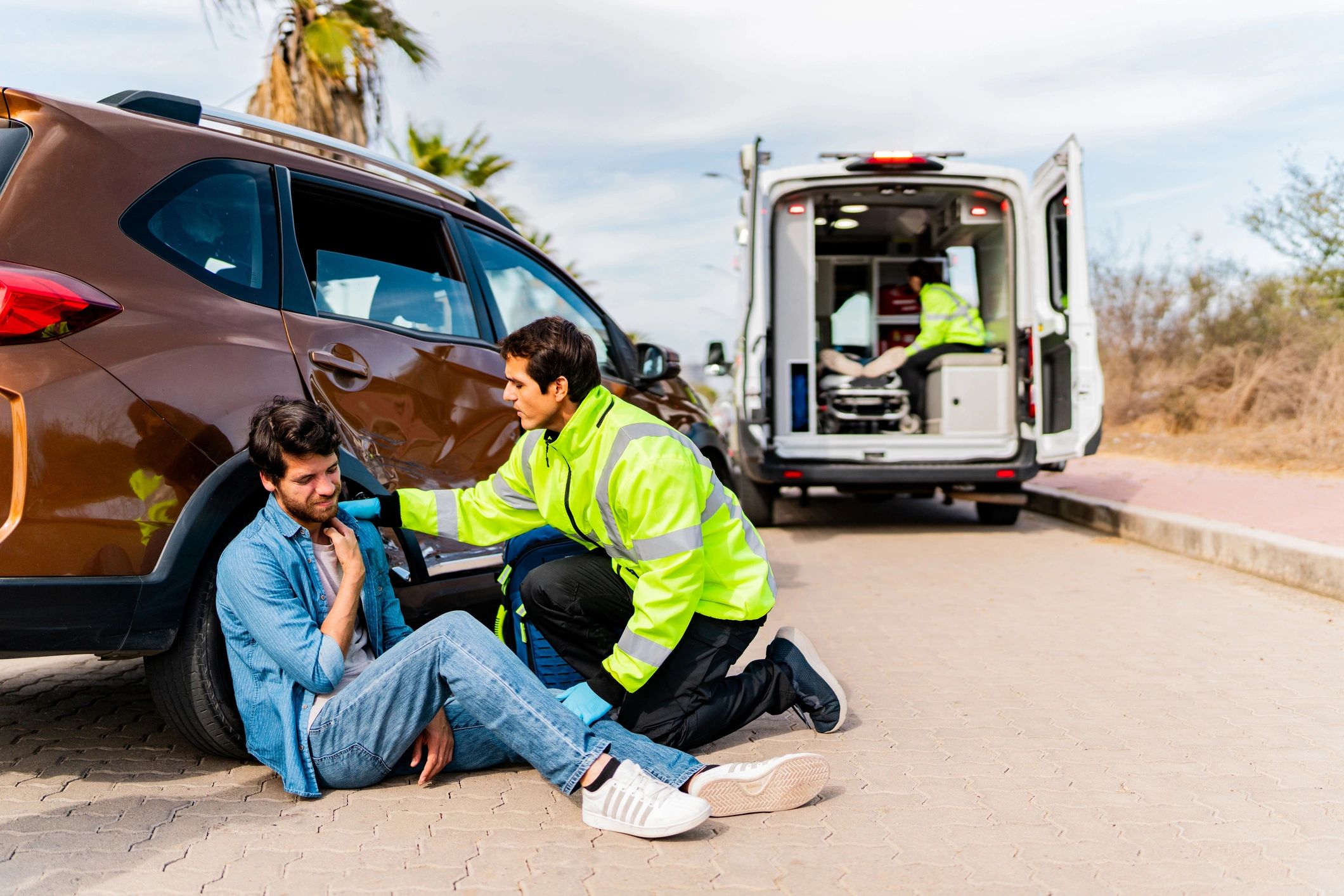 First responder assisting an injured person after a vehicle collision